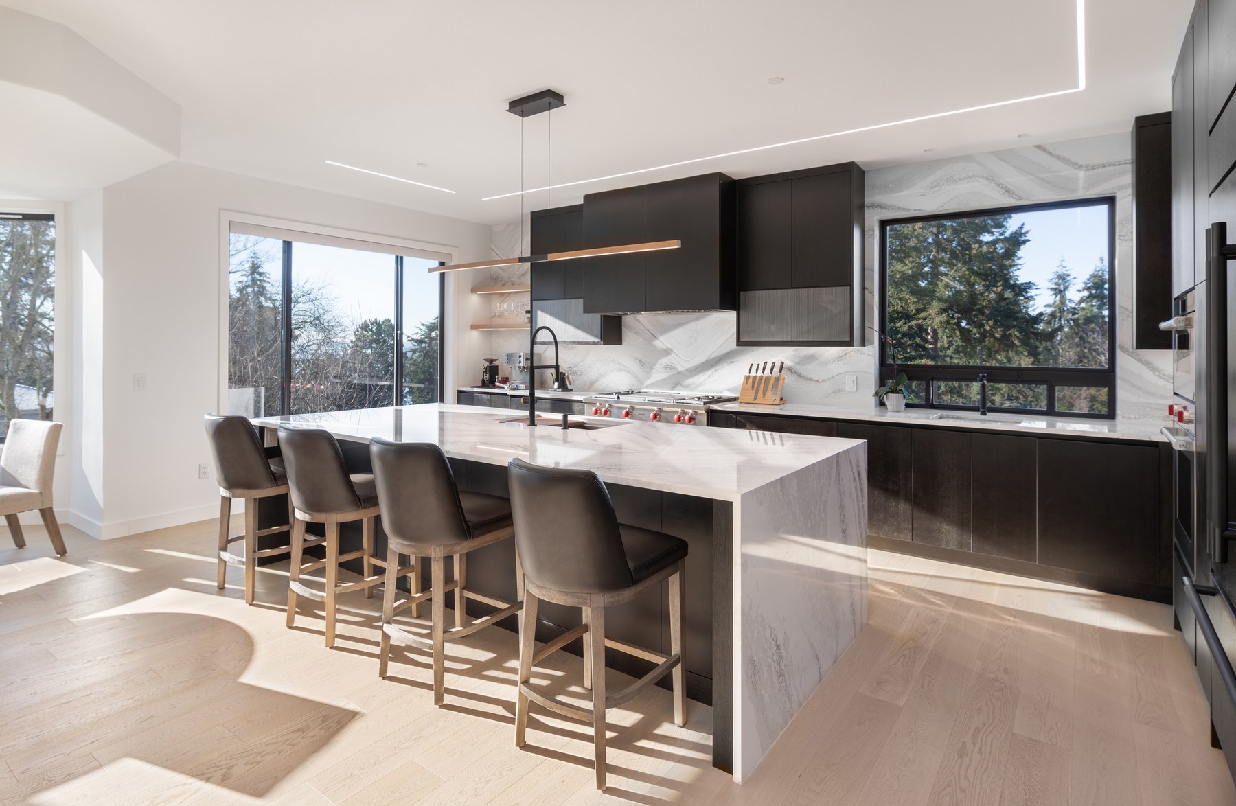 Custom black oak cabinets with bookmatched marble island